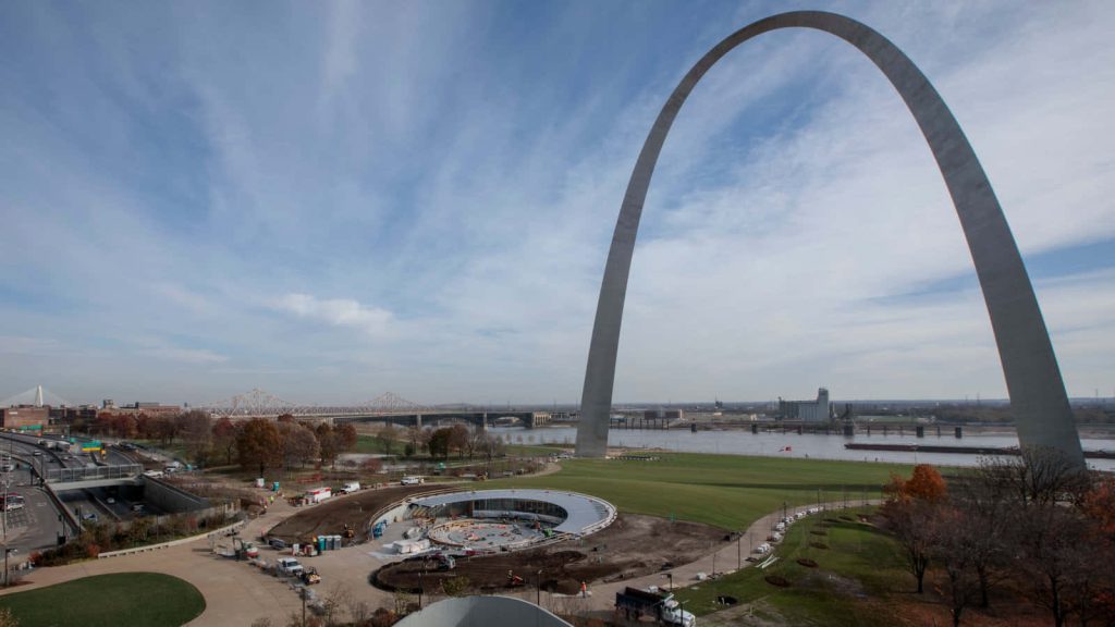 Gateway Arch in St Louis soaring above Mississippi River cityscape and park on clear day wallpaper
