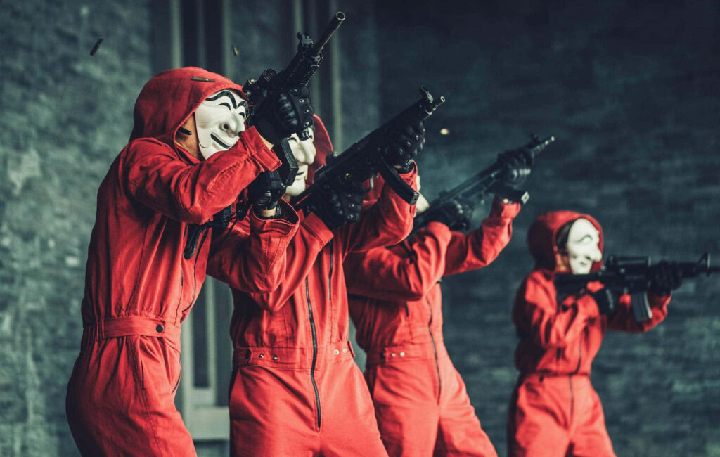 Gearing Up for the Ultimate Heist: Money Heist Characters in Strategic Huddle, Ready for Action Wallpaper