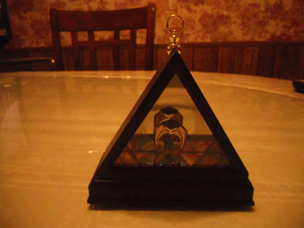 Replica of Gaunt family ring Horcrux in triangular glass case Harry Potter collectible display Wallpaper