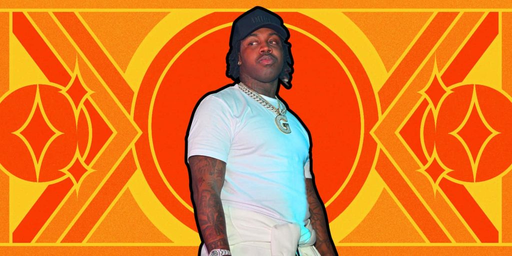 Rapper Gee Money in white tee black cap gold chain on vibrant orange yellow geometric background Wallpaper