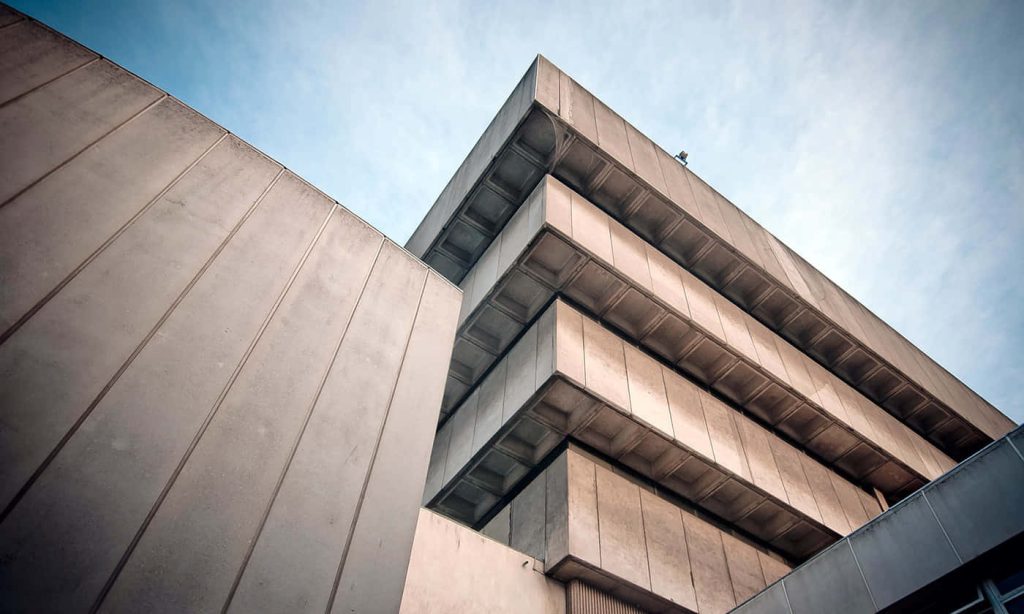 Low-angle view of Geisel Library brutalist concrete architecture with clear sky background Wallpaper