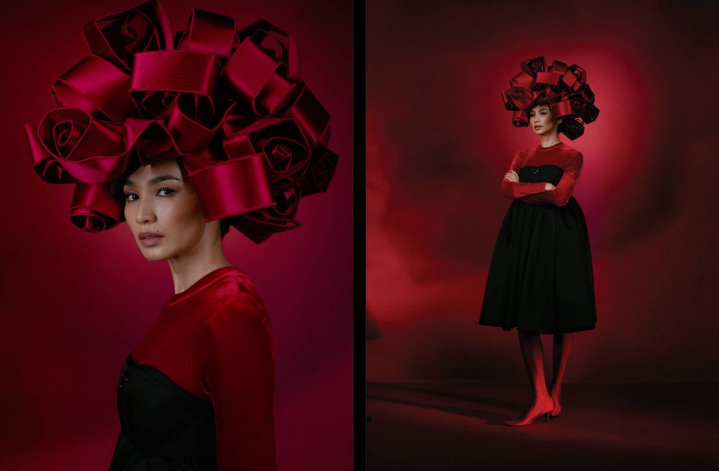 Gemma Chan in sculptural red ribbon headpiece black velvet dress moody red lighting portrait Wallpaper