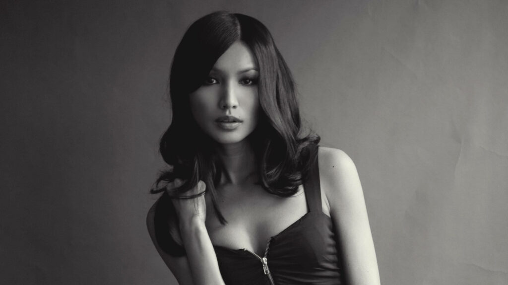 Gemma Chan's Sultry Pose Accentuates Her Alluring Charm in an Elegant Setting Wallpaper