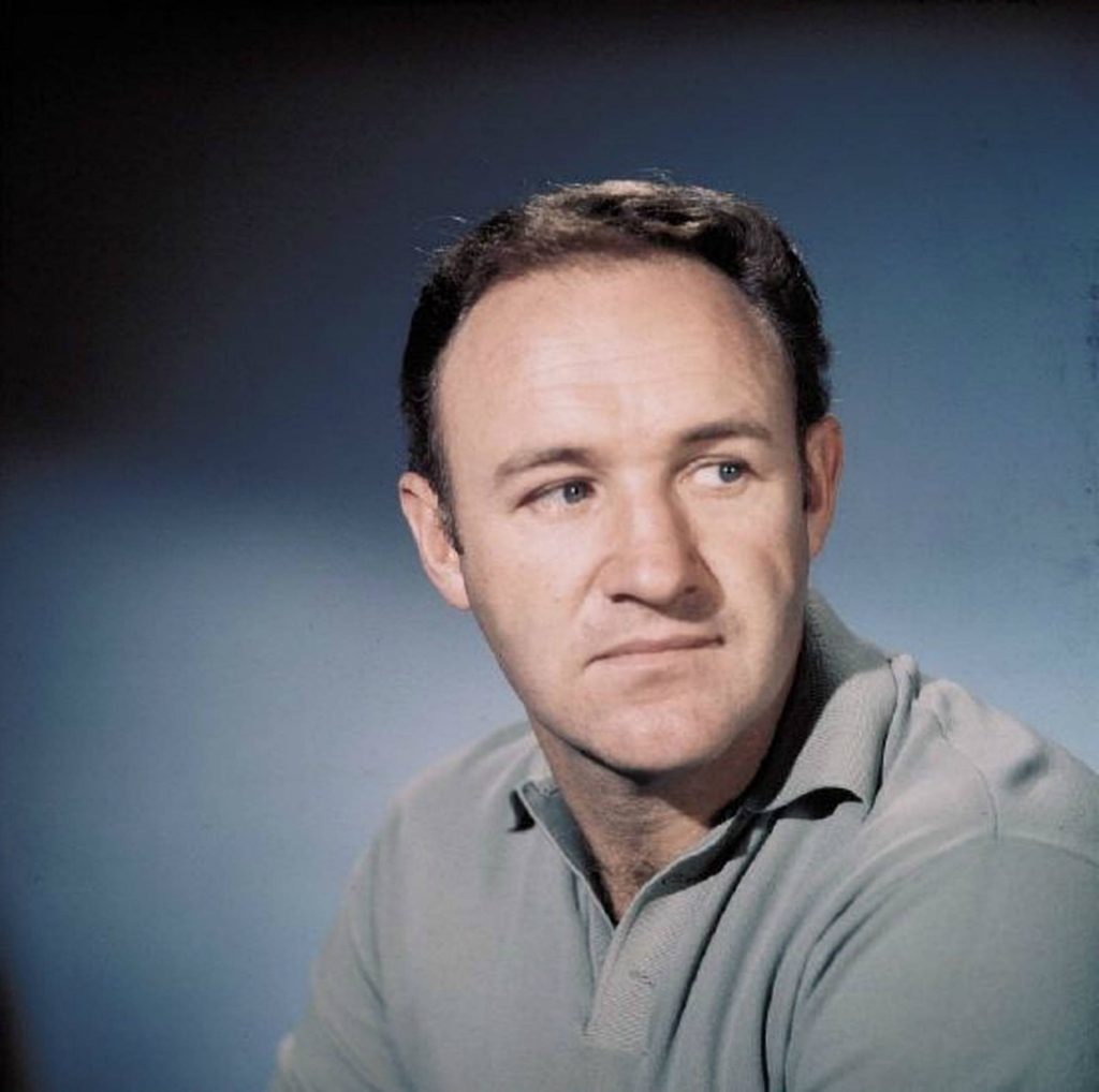 Gene Hackman studio portrait in soft light wearing polo shirt muted blue background wallpaper