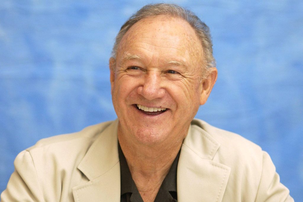 Gene Hackman professional portrait in beige blazer with blue textured background wallpaper