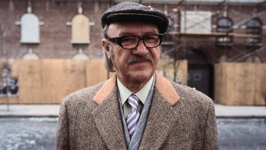 Gene Hackman classic portrait vintage style flat cap herringbone coat brick background wallpaper