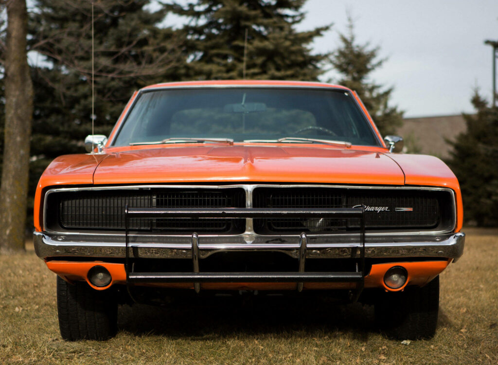 Bold front view of General Lee car with bright orange paint and classic grille outdoors background Wallpaper
