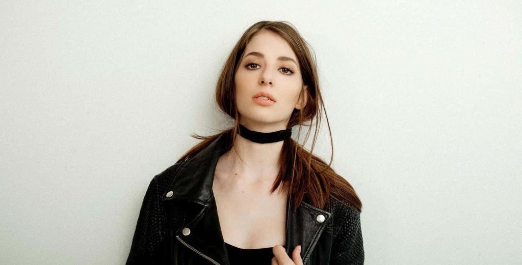 Genevieve Buechner portrait in black leather jacket and choker on white background wallpaper