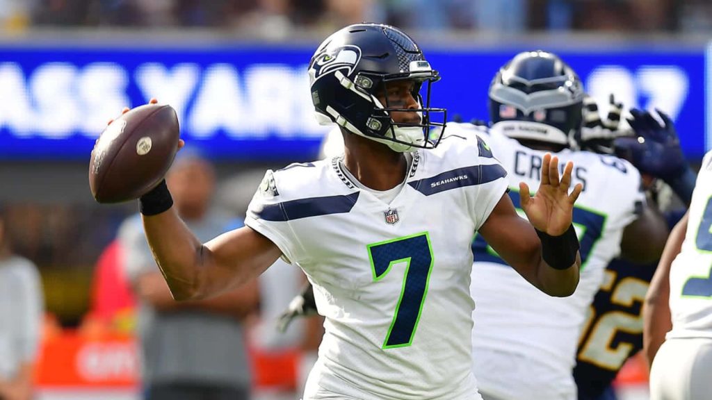 Seattle Seahawks quarterback Geno Smith in white jersey throwing a dynamic NFL pass wallpaper