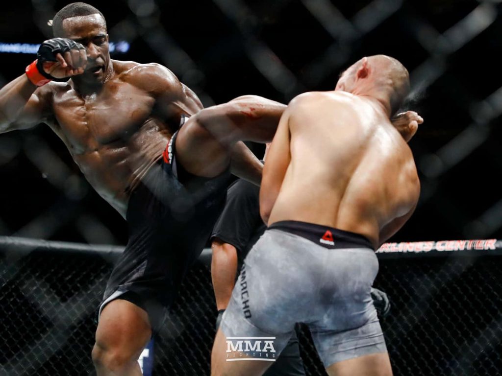Geoff Neal delivers a powerful kick to Frank Camacho in intense UFC cage fight action wallpaper