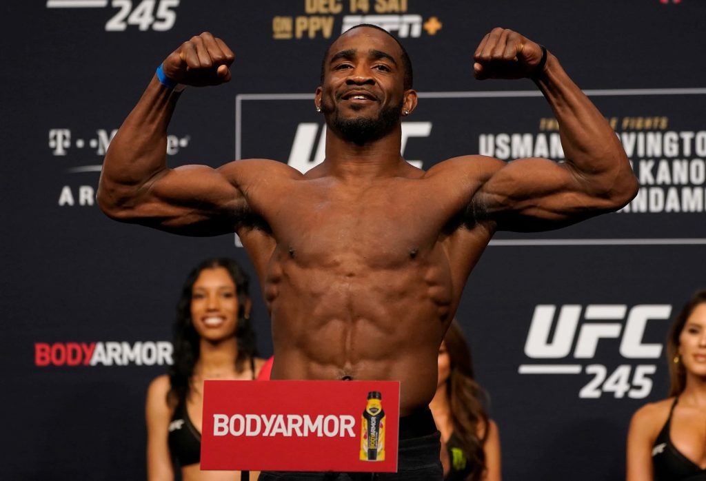 UFC fighter Geoff Neal flexing muscles at UFC 245 weigh-ins dark branded background wallpaper