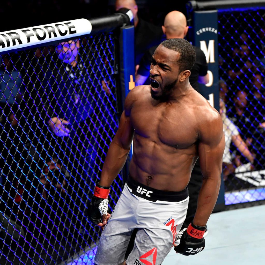 UFC welterweight Geoff Neal celebrating victory inside octagon with bright arena lights Wallpaper