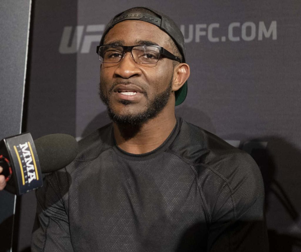 UFC welterweight Geoff Neal in glasses and cap during interview with MMA microphone and UFC backdrop Wallpaper