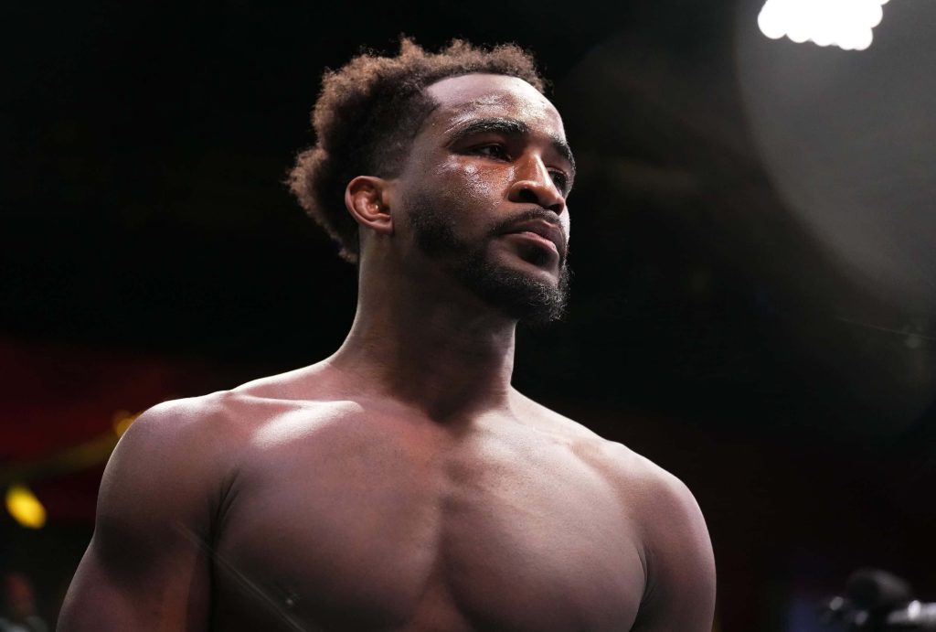 UFC welterweight Geoff Neal focused in dramatic lighting against dark arena background wallpaper