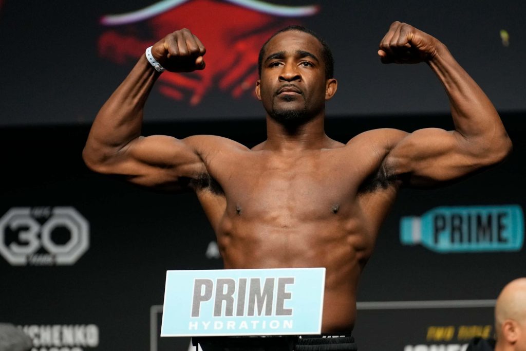 UFC fighter Geoff Neal muscular focused at weigh-in with PRIME Hydration branding black backdrop Wallpaper