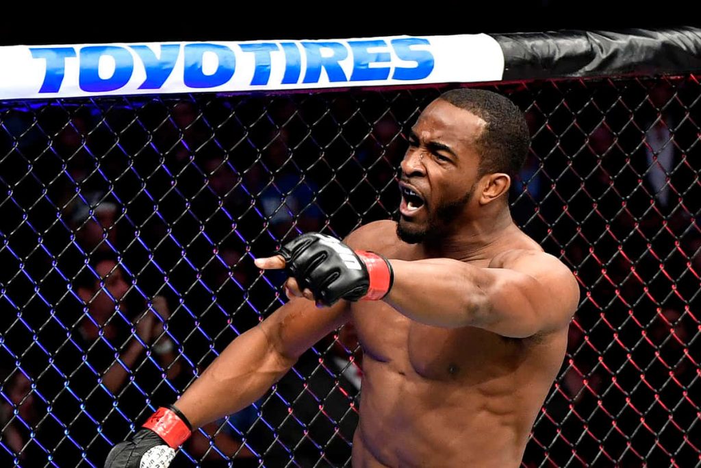 Geoff Neal UFC fighter celebrating inside Octagon with MMA gloves and arena lights background Wallpaper