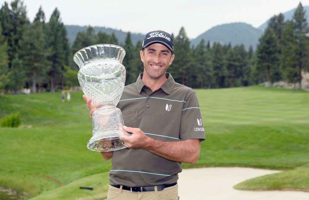 Geoff Ogilvy celebrating 2014 Reno Tahoe Open win holding trophy on green golf course Wallpaper