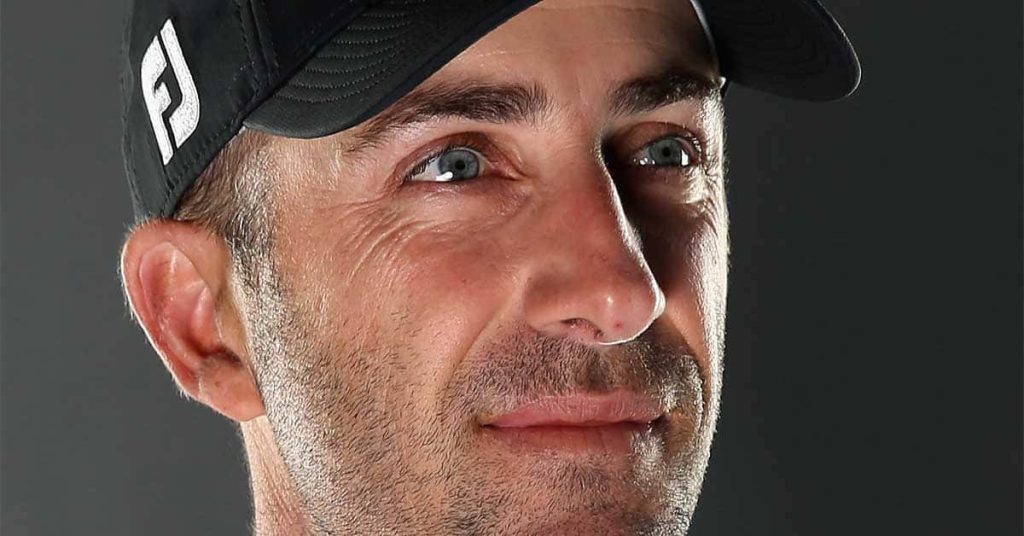 Close-up portrait of golfer Geoff Ogilvy wearing black FootJoy cap with dramatic lighting Wallpaper