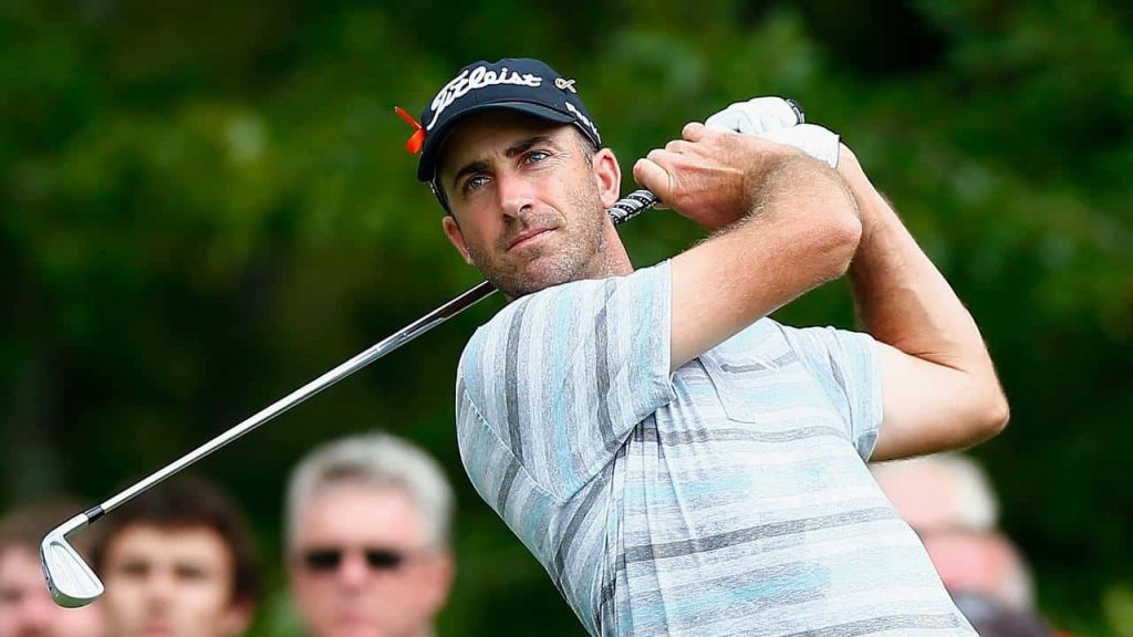 Geoff Ogilvy mid-swing golf action shot in striped polo hat on lush green fairway wallpaper background