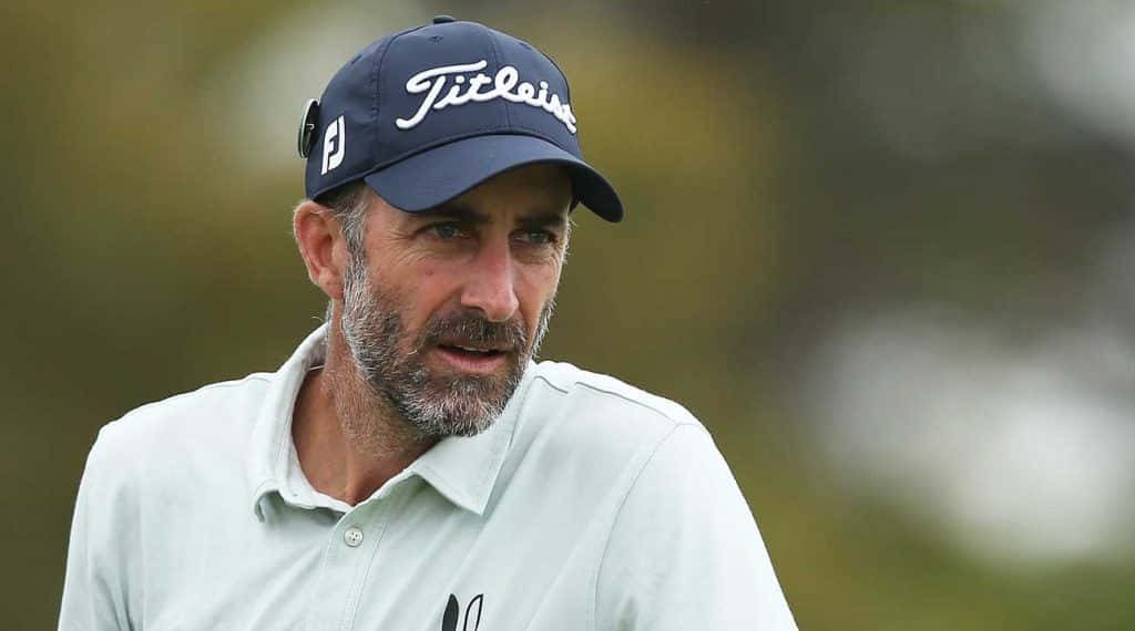 Geoff Ogilvy professional golfer portrait wearing navy Titleist cap focused outdoor background Wallpaper