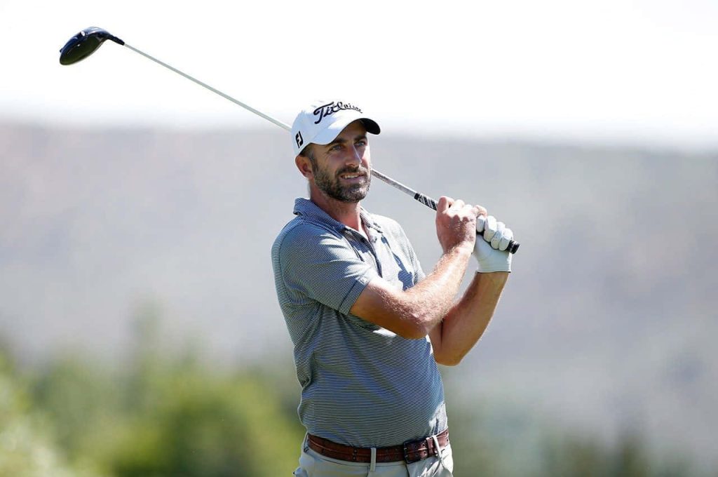 Professional golfer Geoff Ogilvy mid-swing in grey polo and Titleist cap outdoor golf wallpaper