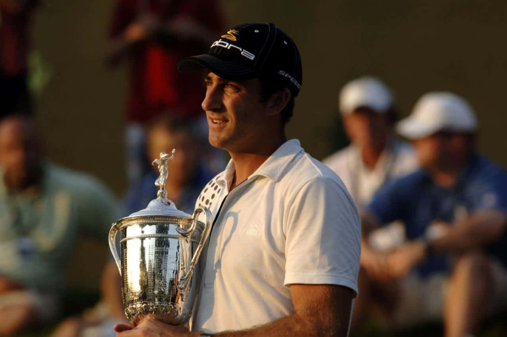 Geoff Ogilvy holds US Open trophy in white shirt and Cobra cap with sunlit golf gallery background Wallpaper