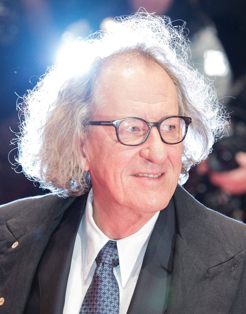 Geoffrey Rush portrait with glasses dark suit dramatic backlight halo professional wallpaper background