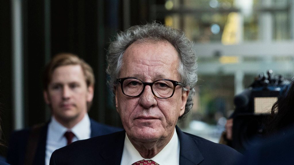 Geoffrey Rush serious portrait in dark suit and glasses against blurred urban background wallpaper