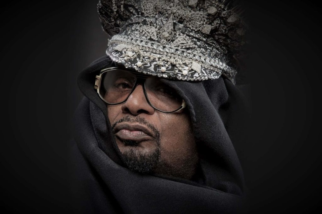 George Clinton funk legend portrait black hooded cloak jewel headpiece moody lighting wallpaper