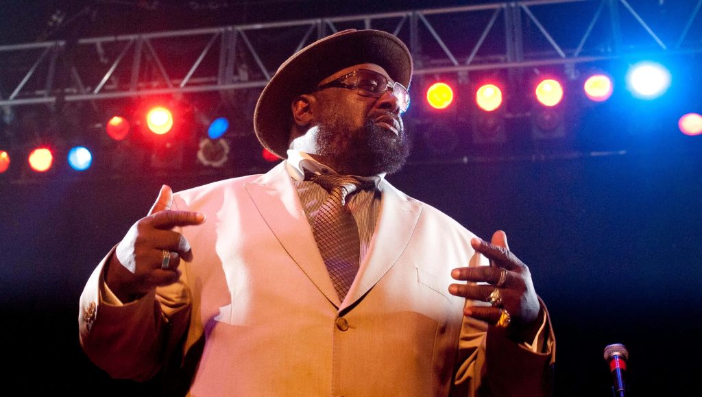George Clinton live concert wallpaper vibrant red and blue lighting funk music legend on stage
