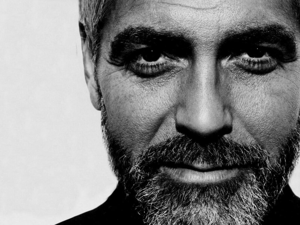 Black and white close-up portrait of George Clooney with expressive eyes and distinguished features Wallpaper