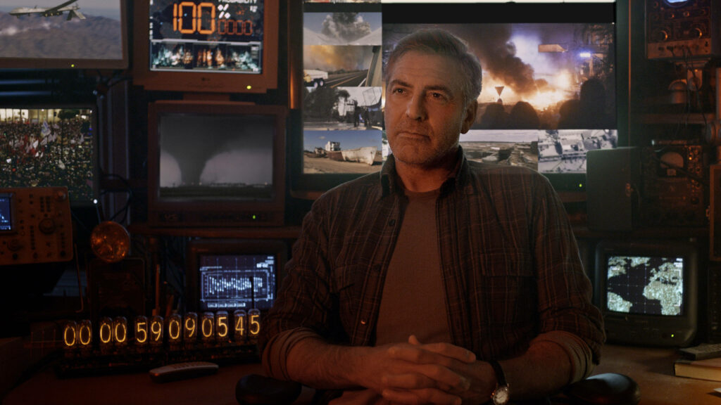 George Clooney in control room with multiple screens showcasing dramatic film scenes wallpaper background