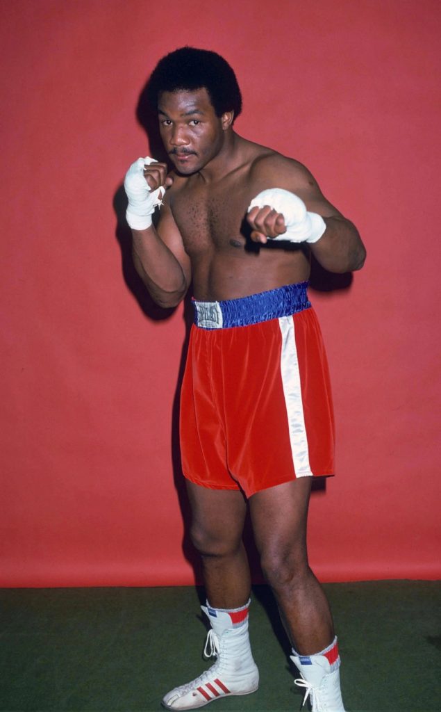 Vintage studio portrait of heavyweight boxing legend George Foreman in red trunks stance Wallpaper