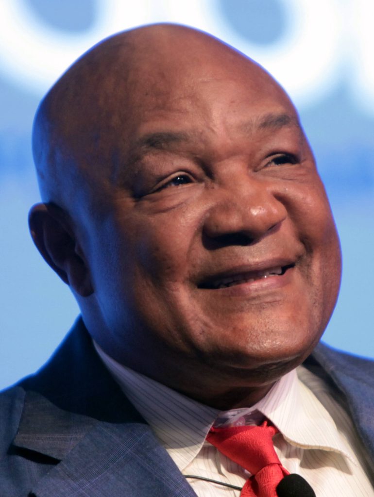 George Foreman portrait wearing blue suit and red tie smiling close-up wallpaper background