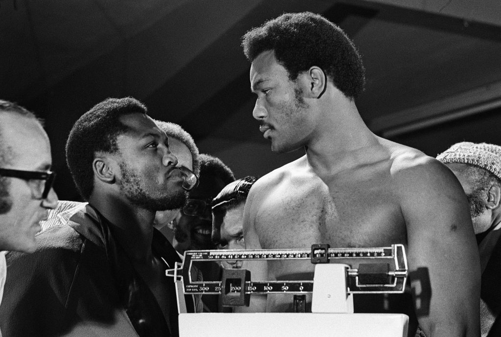 Iconic 1973 black and white photo of George Foreman and Joe Frazier intense weigh-in stare down Wallpaper