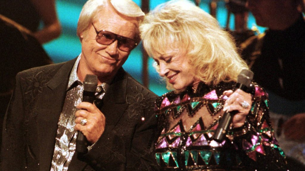 George Jones and Tammy Wynette duet performing live vibrant country music concert wallpaper background