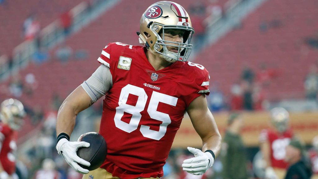 George Kittle 49ers running with football in red jersey gold helmet NFL action wallpaper