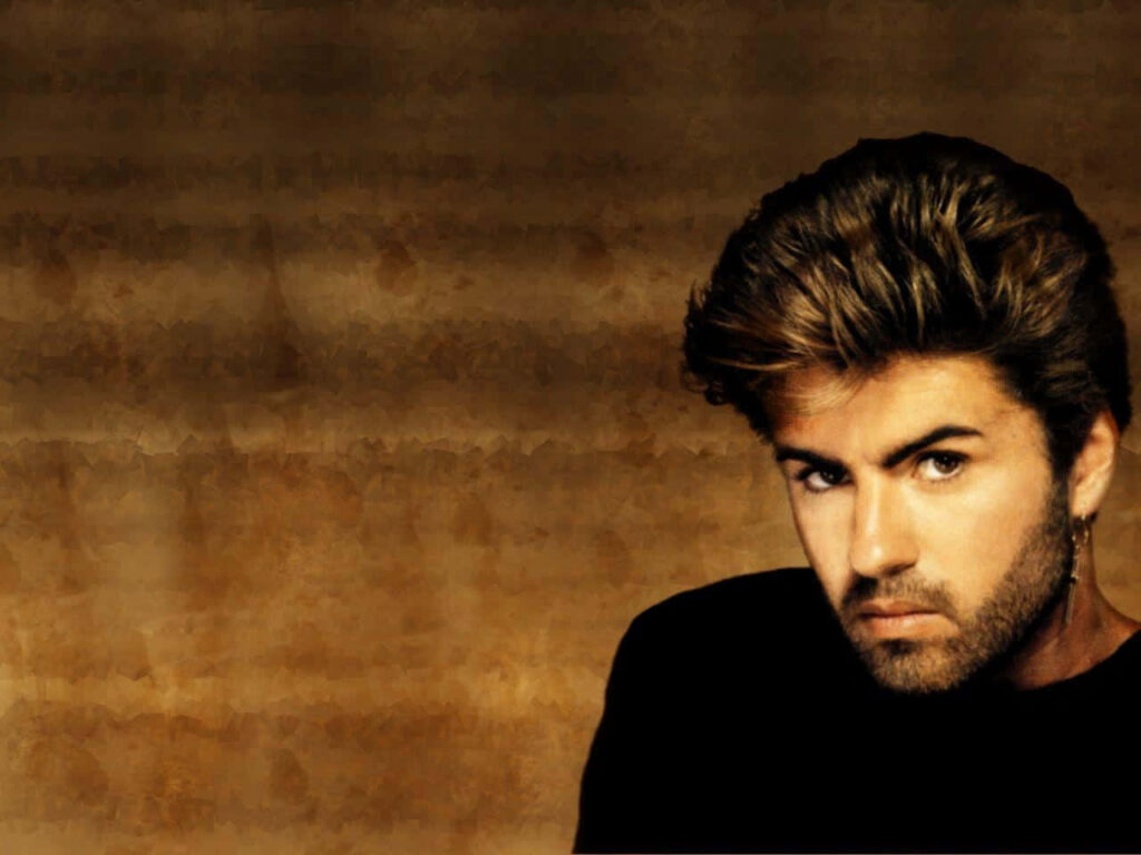 George Michael Portrait Wallpaper: Focused Expression on Warm Background
