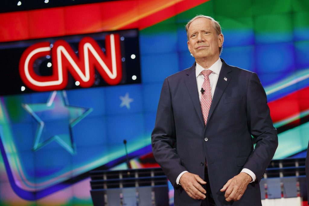 George Pataki former NY governor in suit on CNN debate stage with glowing logo backdrop wallpaper
