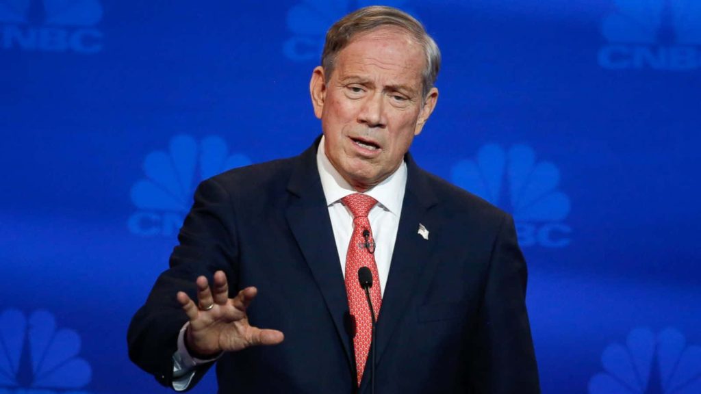 George Pataki in dark suit and red tie speaking at CNBC debate with blue branded backdrop Wallpaper