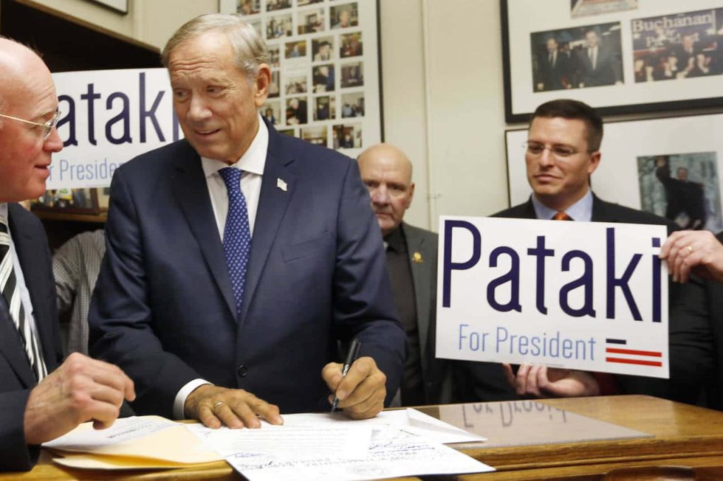 George Pataki signing campaign documents with aides and Pataki For President signs in office Wallpaper