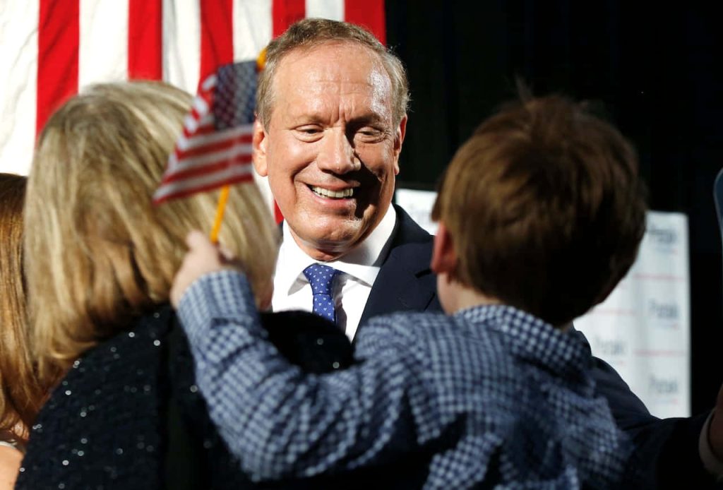 George Pataki smiling at child waving American flag at patriotic political event background Wallpaper