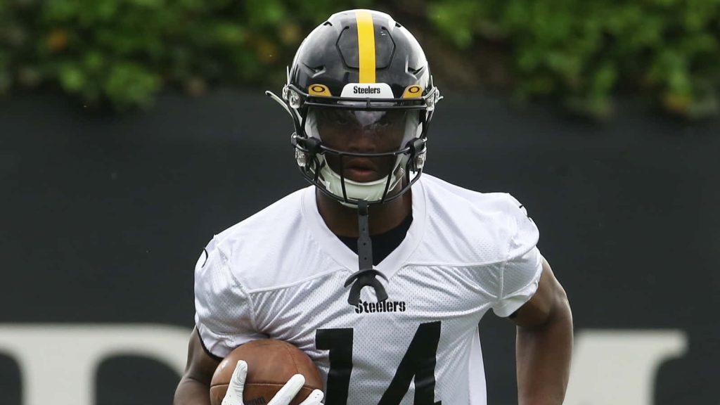 George Pickens Pittsburgh Steelers wide receiver in white jersey gripping football intense action Wallpaper