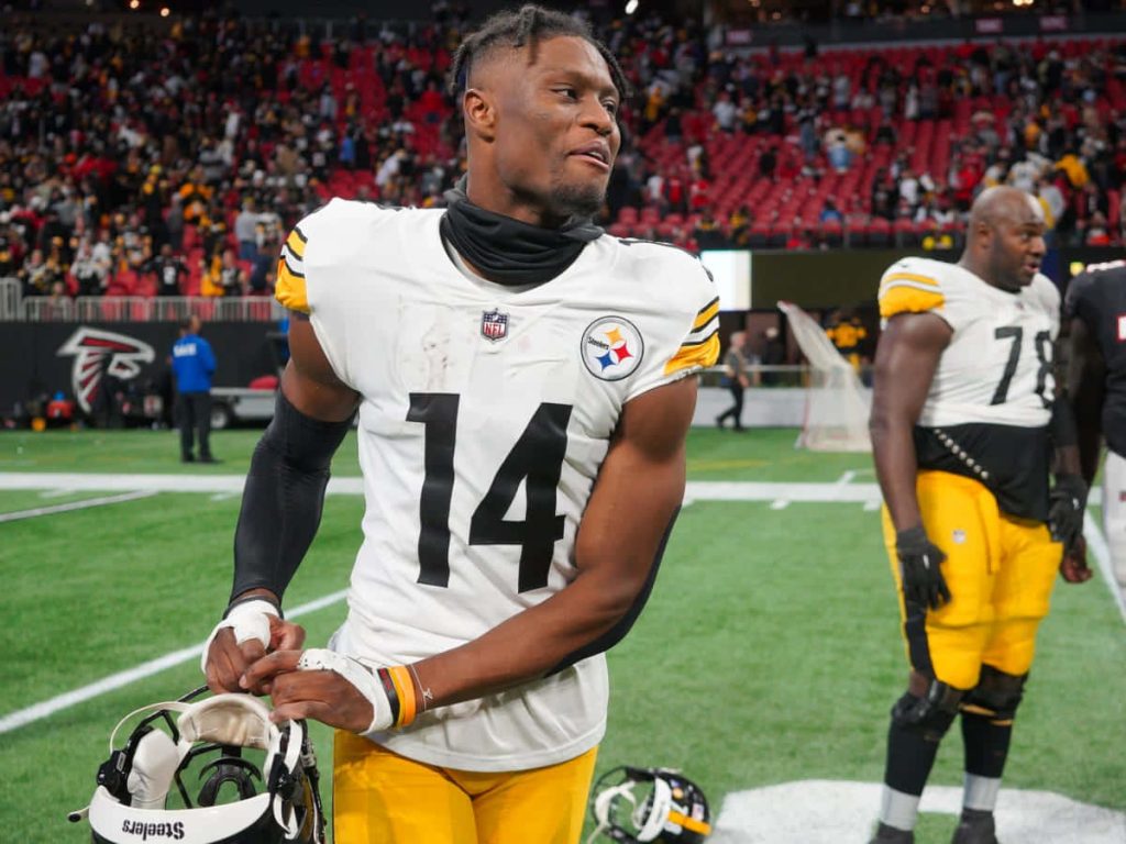 Pittsburgh Steelers George Pickens in white jersey holding helmet on NFL turf field wallpaper