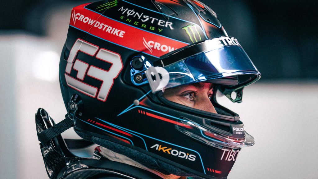 Close-up of F1 driver George Russell in Mercedes AMG racing helmet black red cyan wallpaper