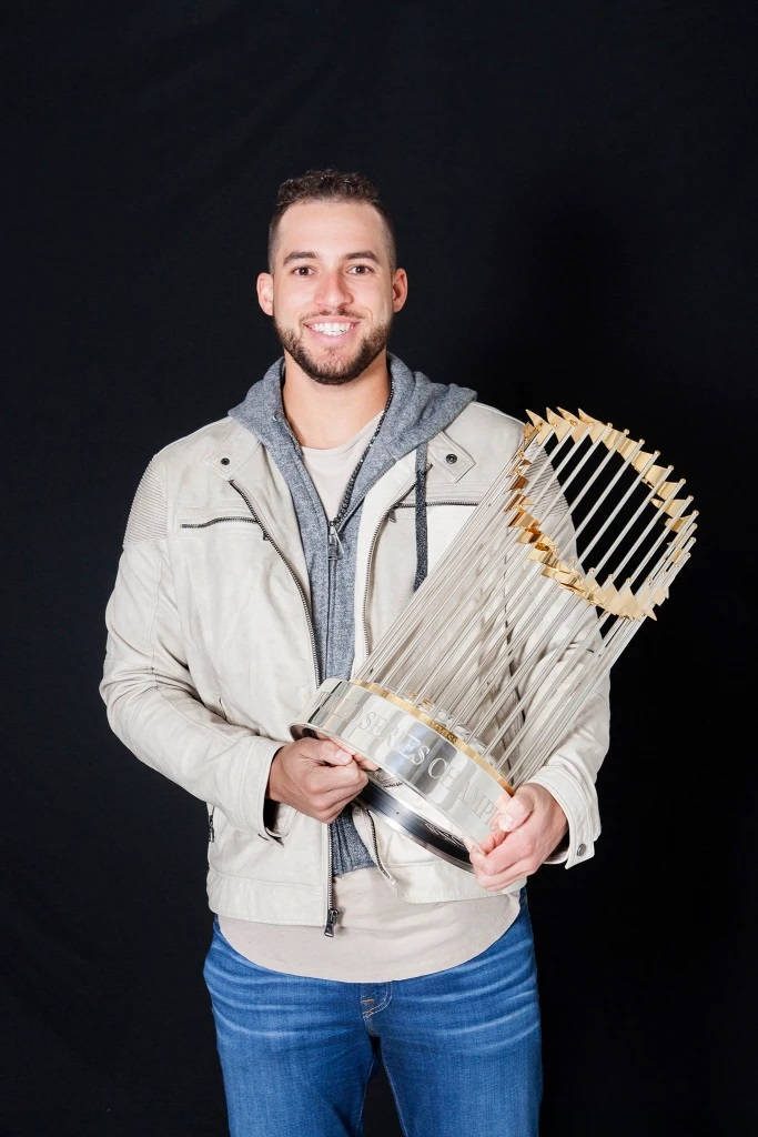 George Springer in cream moto jacket holding 2017 World Series Commissioner's Trophy portrait Wallpaper