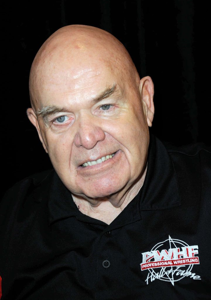 Close-up portrait of George The Animal Steele in black Wrestling Hall of Fame polo shirt on black background Wallpaper