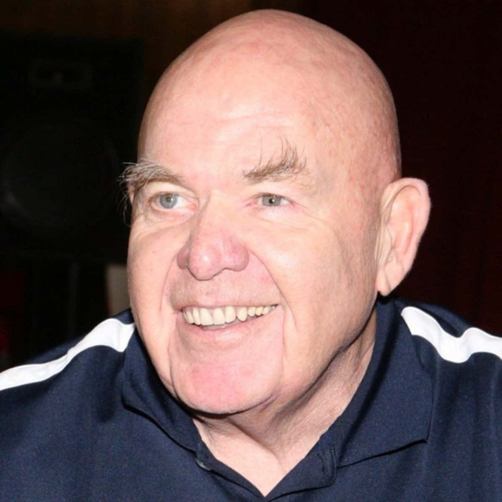 Portrait of wrestler George The Animal Steele smiling in blue striped polo high-quality wallpaper