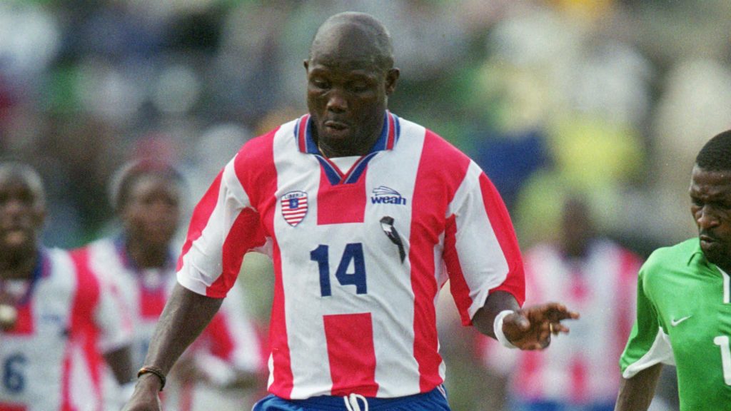 George Weah in red and white number 14 jersey celebrating on pitch Liberia football legend wallpaper
