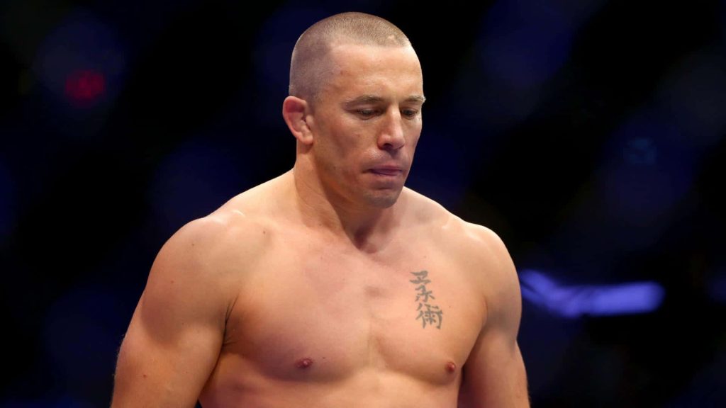 Georges St-Pierre UFC fighter mid-shot shirtless with kanji tattoo in dark arena background wallpaper